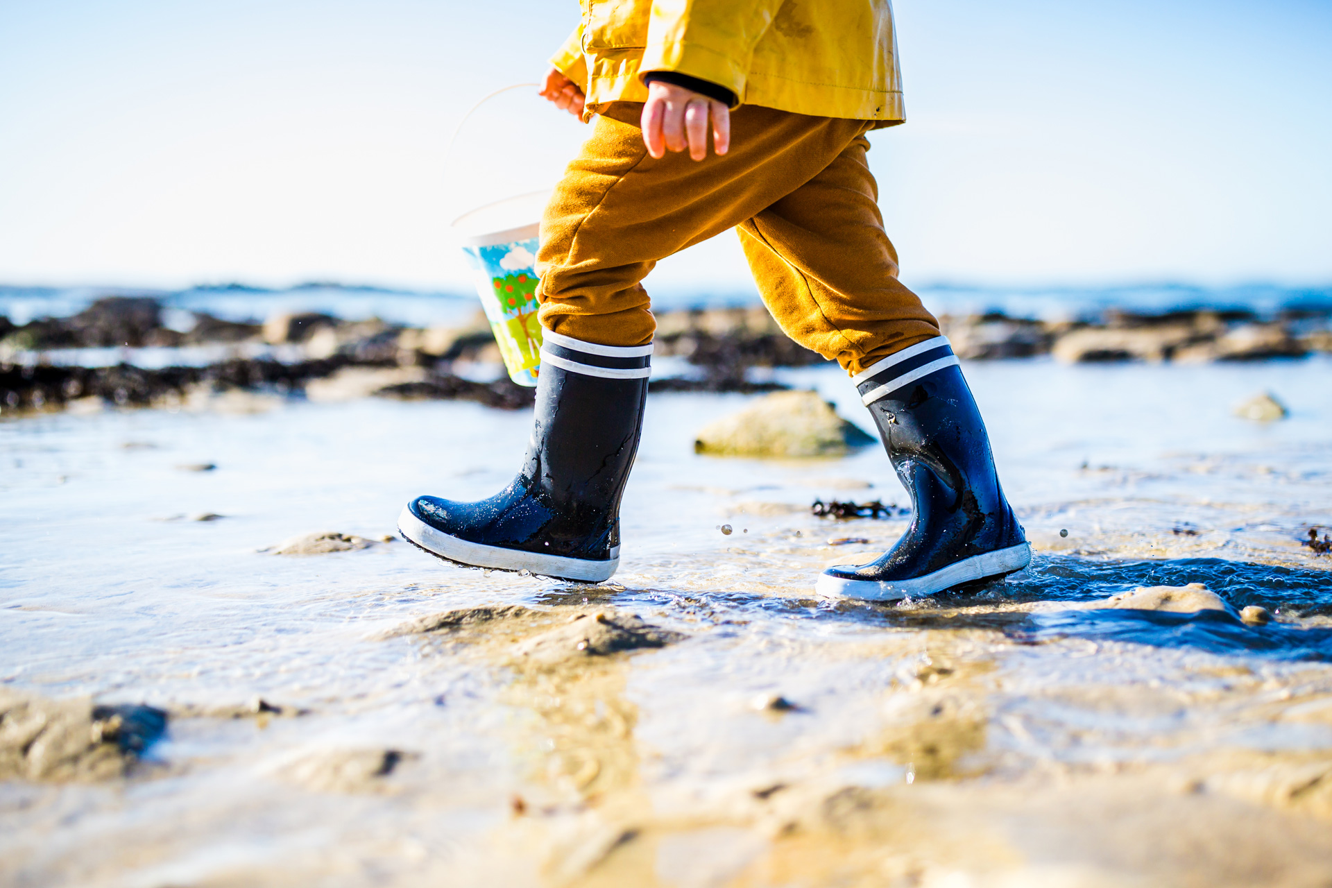 Enfant avec des bottes marchant dans l'eau